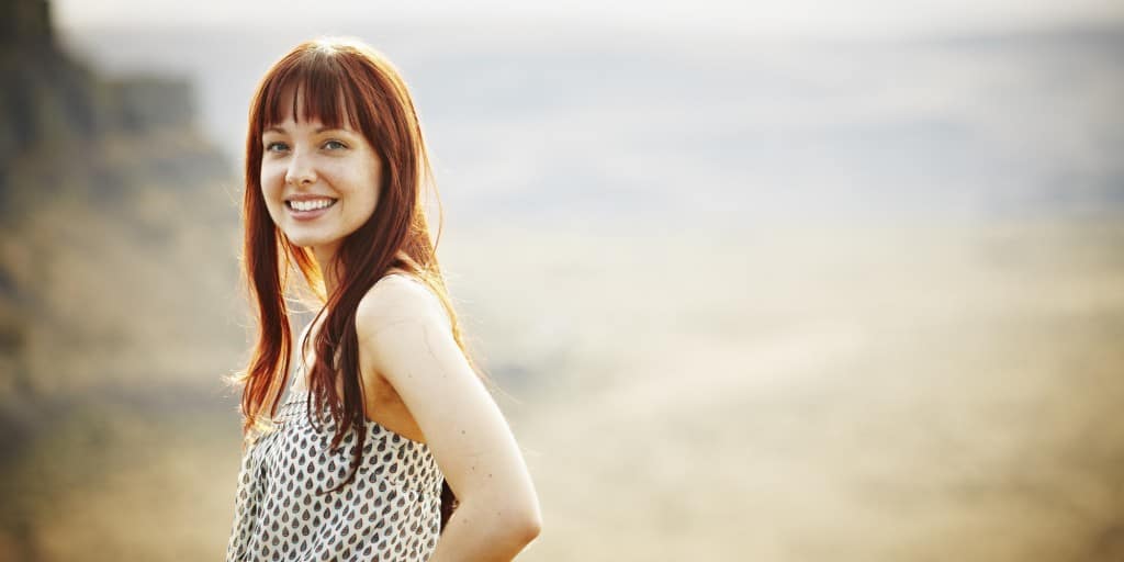 Smiling woman standing with hands on hips