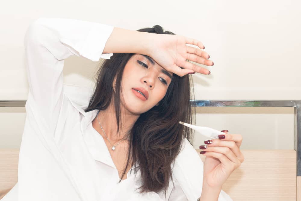 Woman,measuring,temperature,her,body,on,the,bed.,person,got