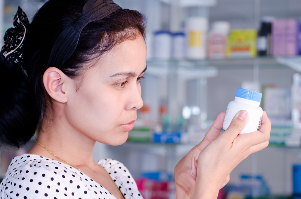 Portrait,of,asian,woman,reading,label,of,medicine,in,drugstore.