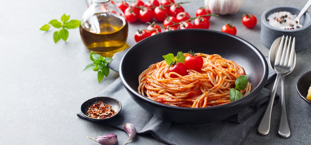 Pasta,,spaghetti,with,tomato,sauce,in,black,bowl,on,grey