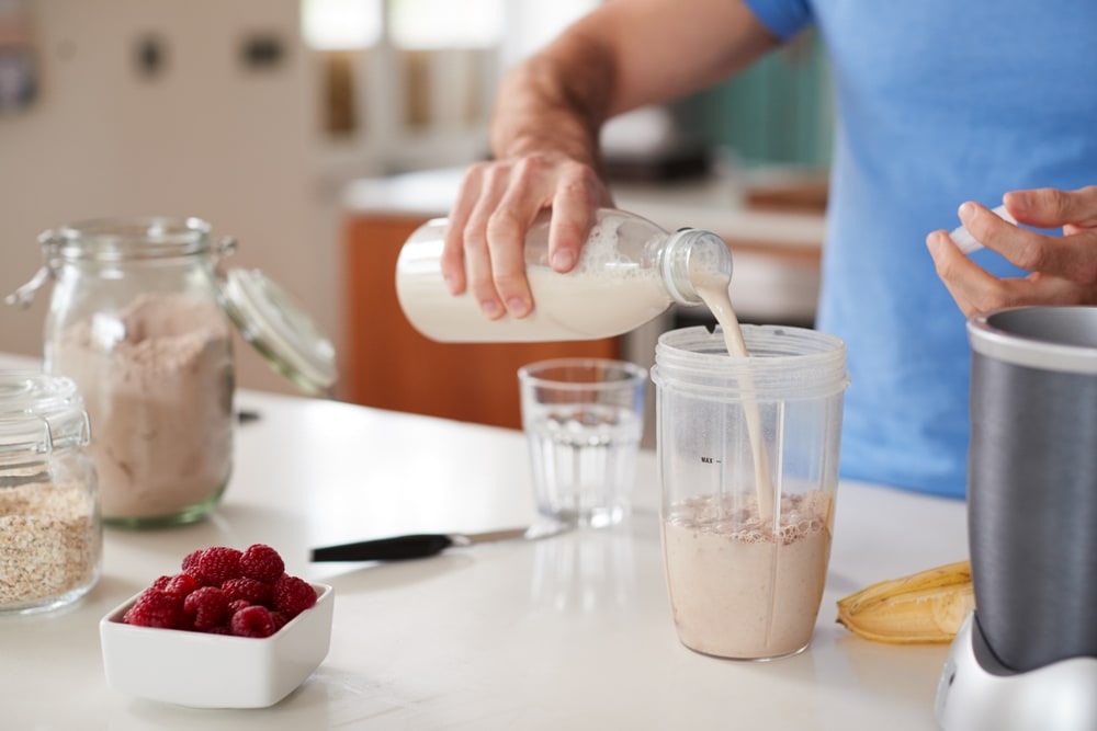 Close,up,of,man,making,protein,shake,after,exercise,at