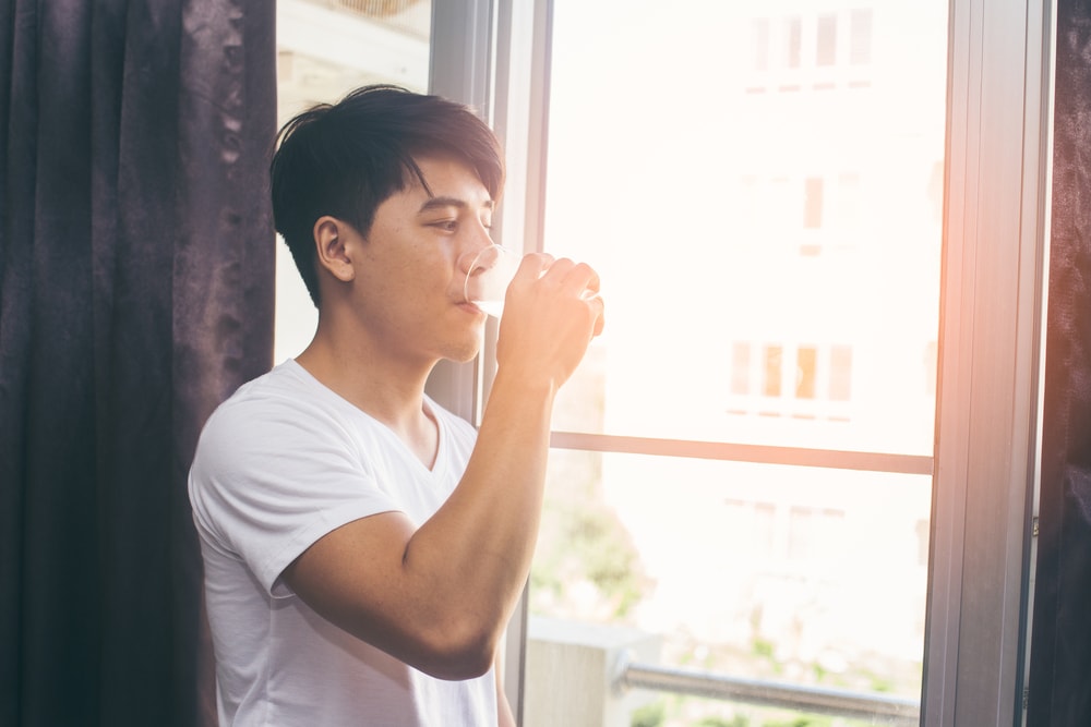 Asian,man,drinking,water,at,the,morning,,vintage,color,tone.
