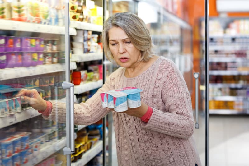Shocked,elderly,woman,reading,product,label,while,choosing,groceries,in