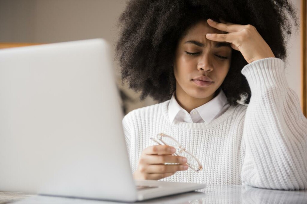 Woman At Computer Looking Stressed One Of The Major Causes Of Irritability Can Be Life Stress